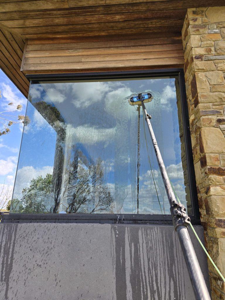 Large picture window being cleaned, showing the frame and sill below the glass
