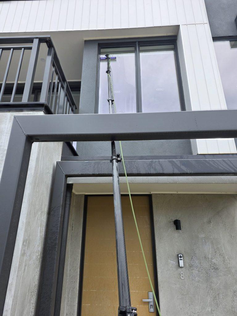 Windows of a newly completed townhouse being cleaned after handover